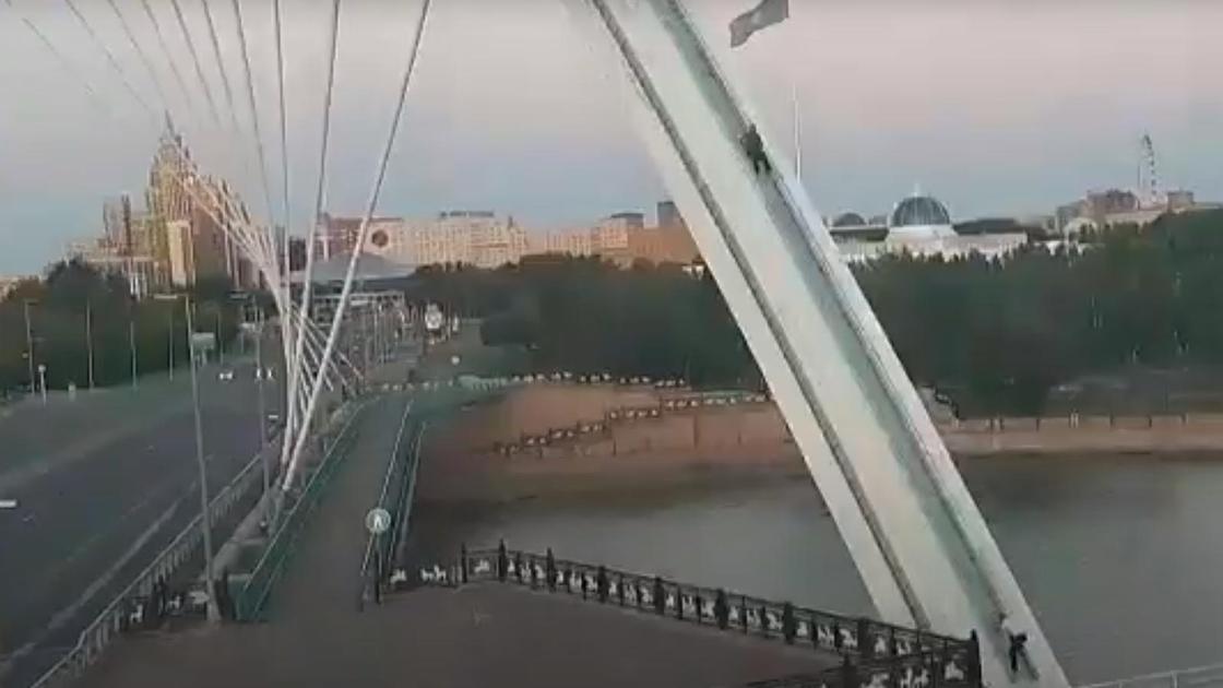 Парни лезут на арку моста