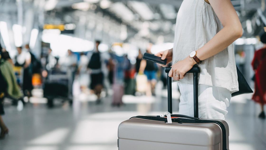 Женщина с чемоданом в аэропорту