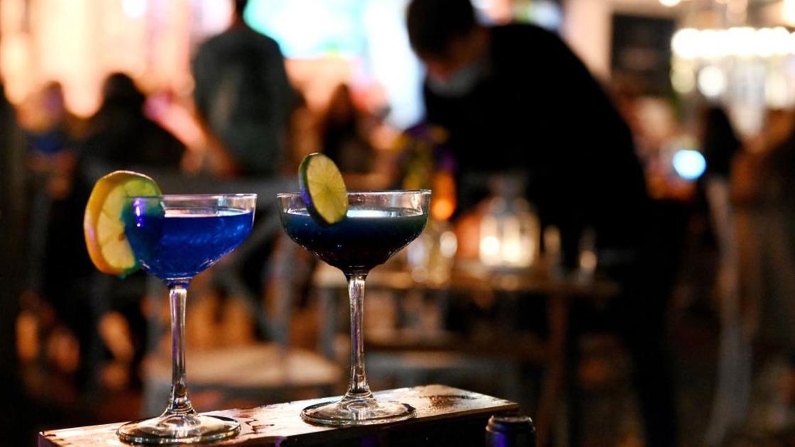 Два бокала с коктейлем стоят на барной стойке