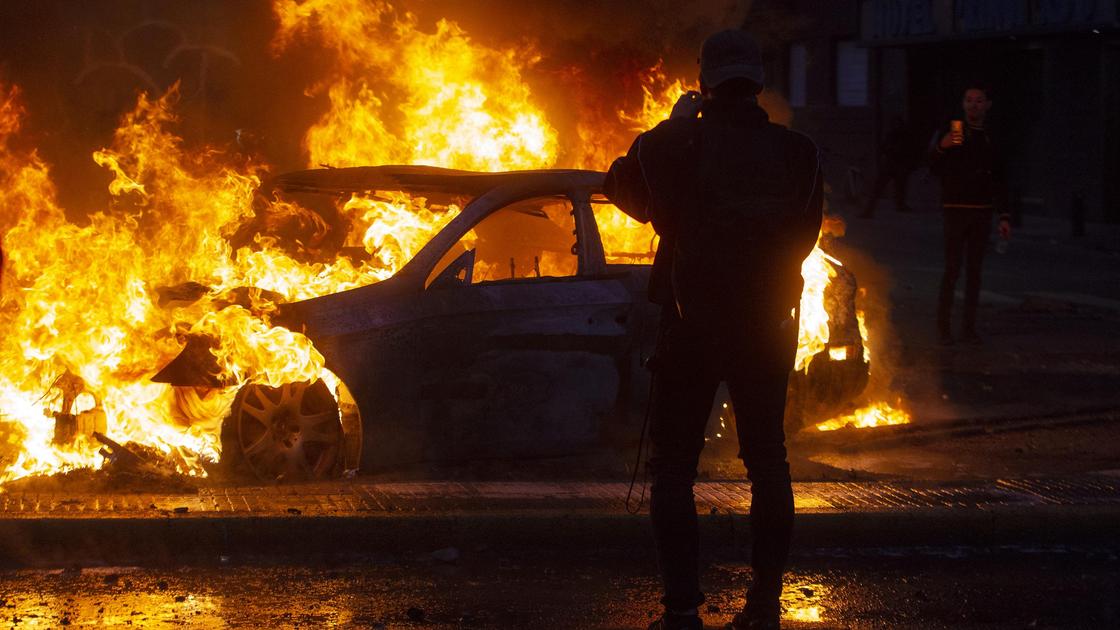 Человек стоит на фоне горящего автомобиля
