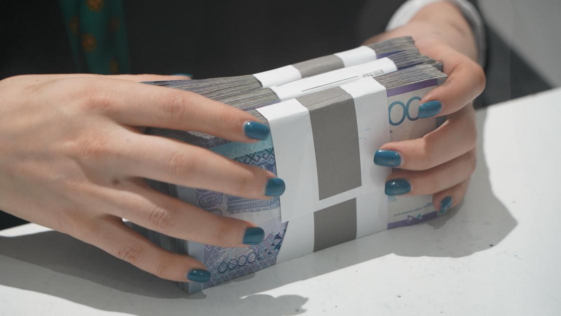 Женщина держит пачки денег