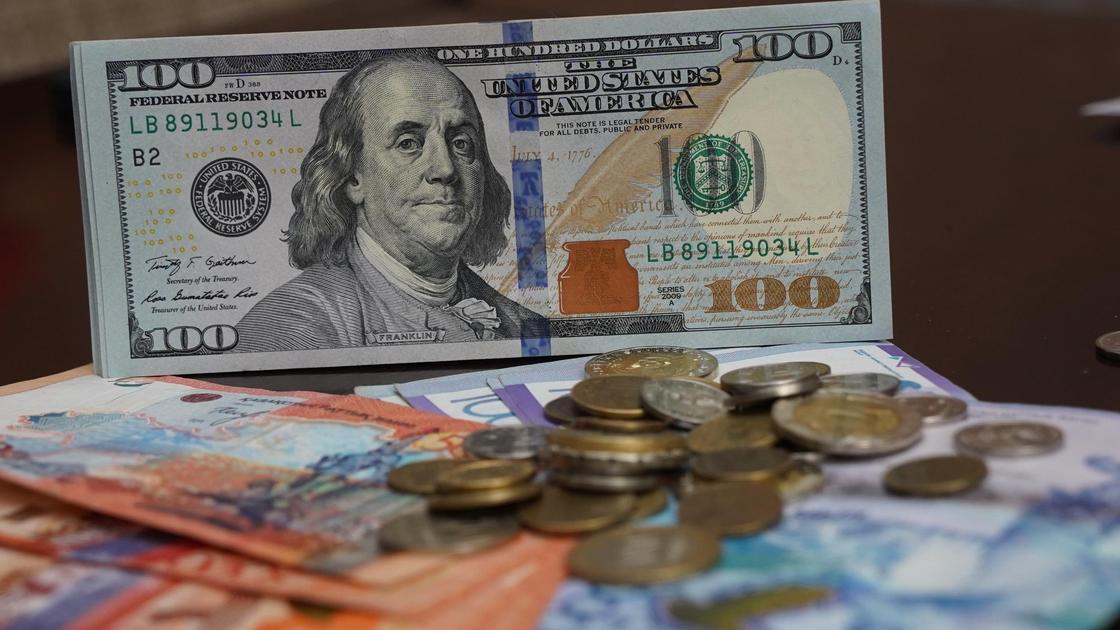Купюры и монеты валют разных стран лежат на столе