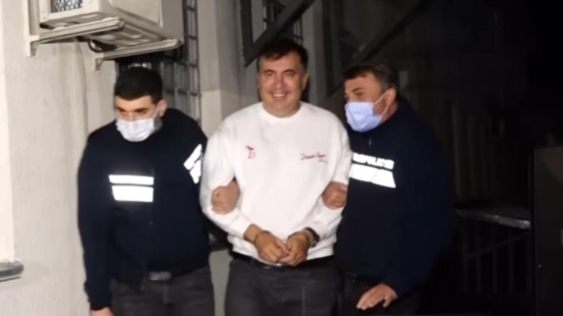 Михаила Саакашвили ведут под руку двое правоохранителей