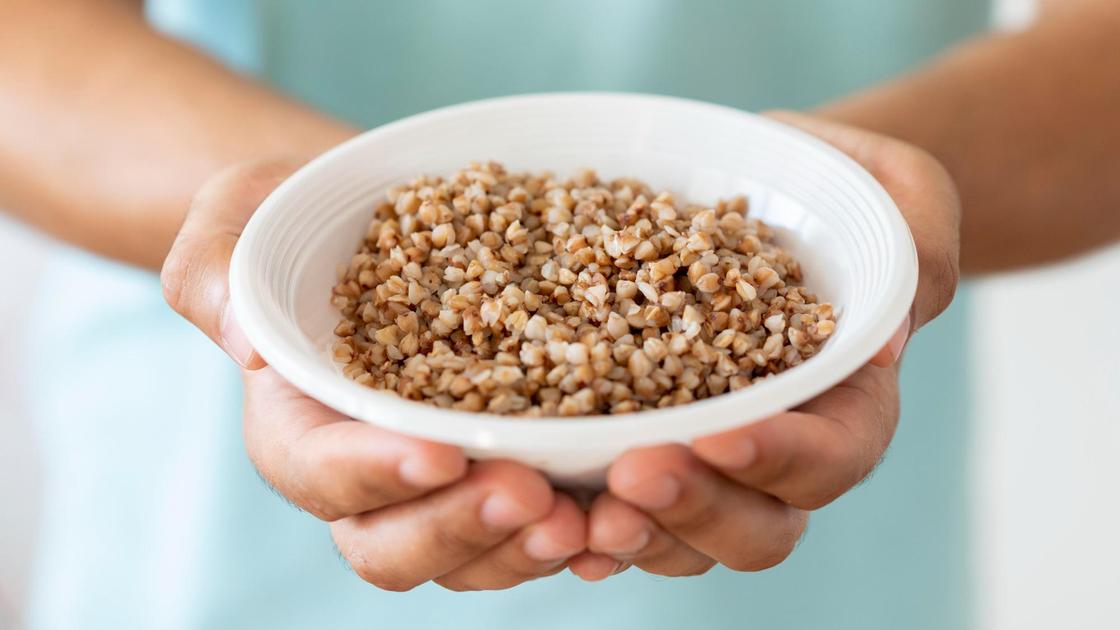 Женщина держит миску с гречневой кашей