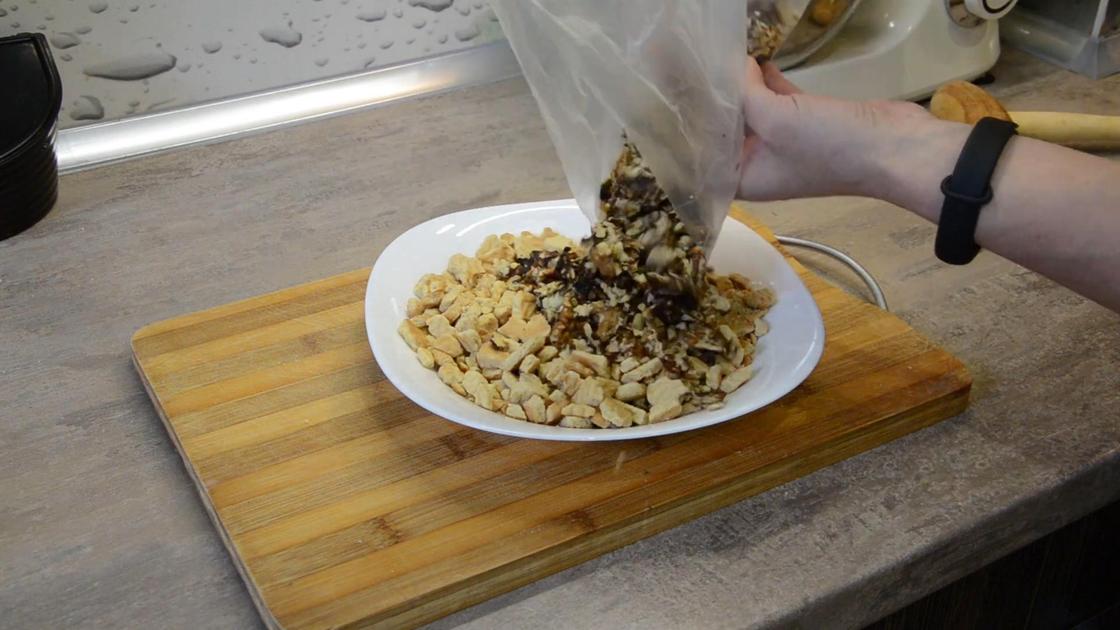 Измельченные орехи из пакета пересыпают в миску с печеньем