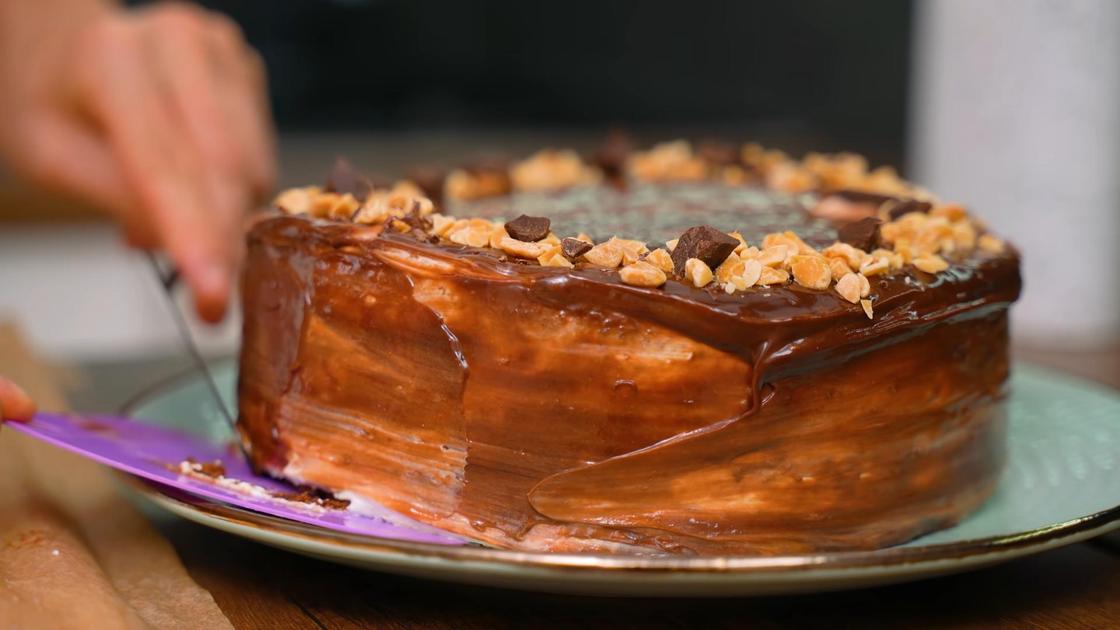Торт «Сникерс» перекладывают на сервировочную тарелку