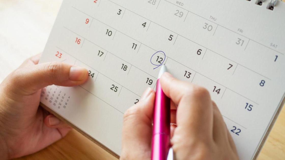 Женщина отмечает даты в календаре