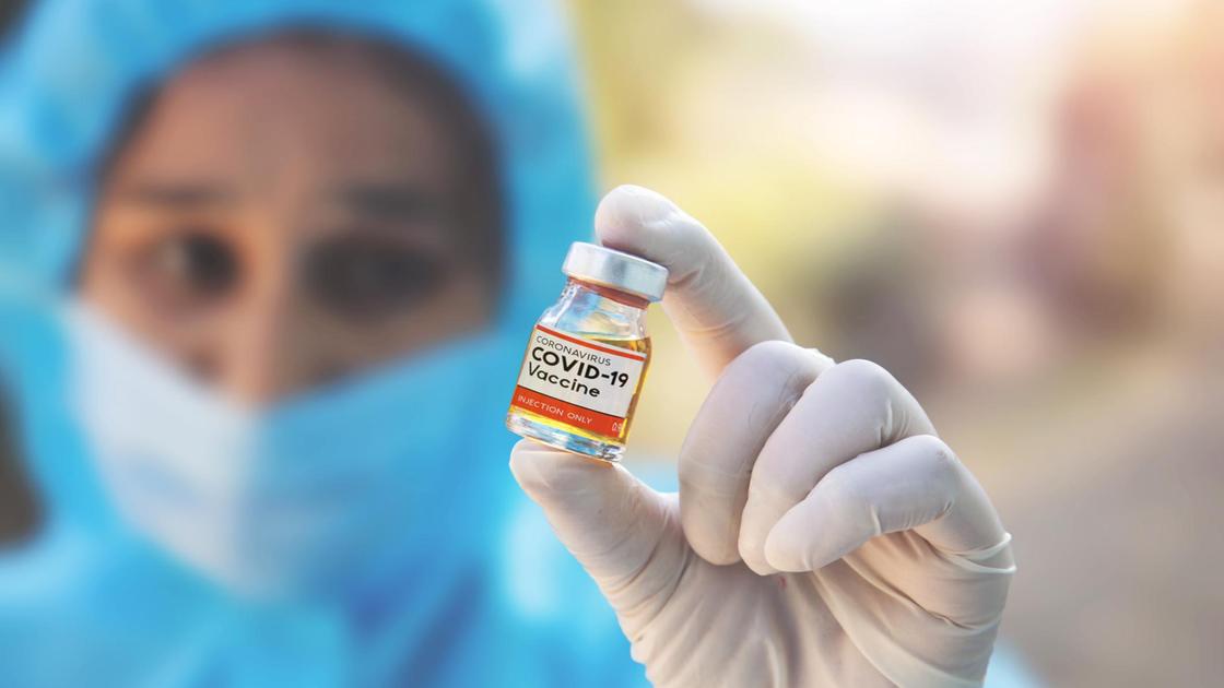 Врач из Индии держит вакцину