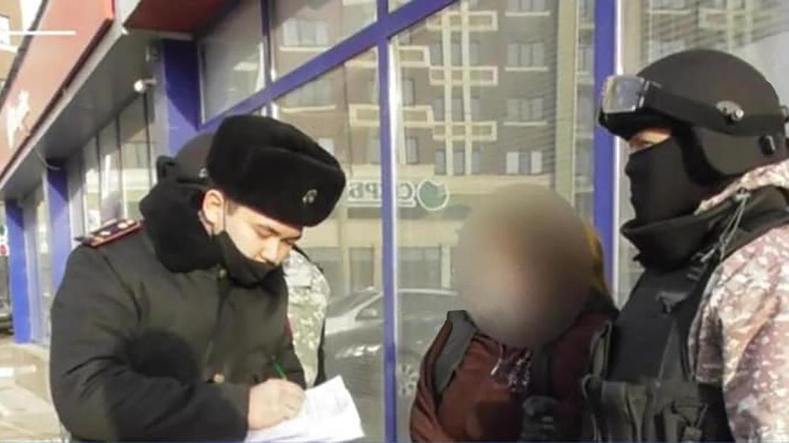 Двое полицейских стоят рядом с подозреваемой Двое полицейских стоят рядом с подозреваемой
