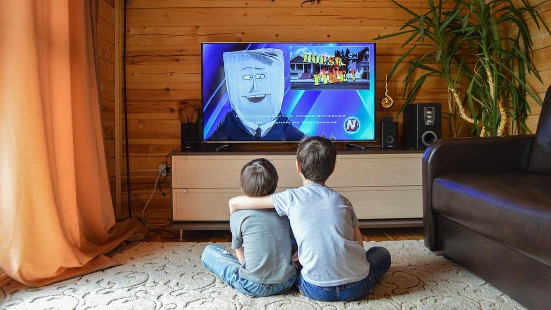 Дети сидят перед экраном телевизора