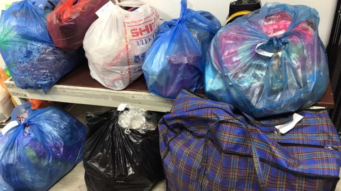 Мешки с товарами лежат на скамейке и земле