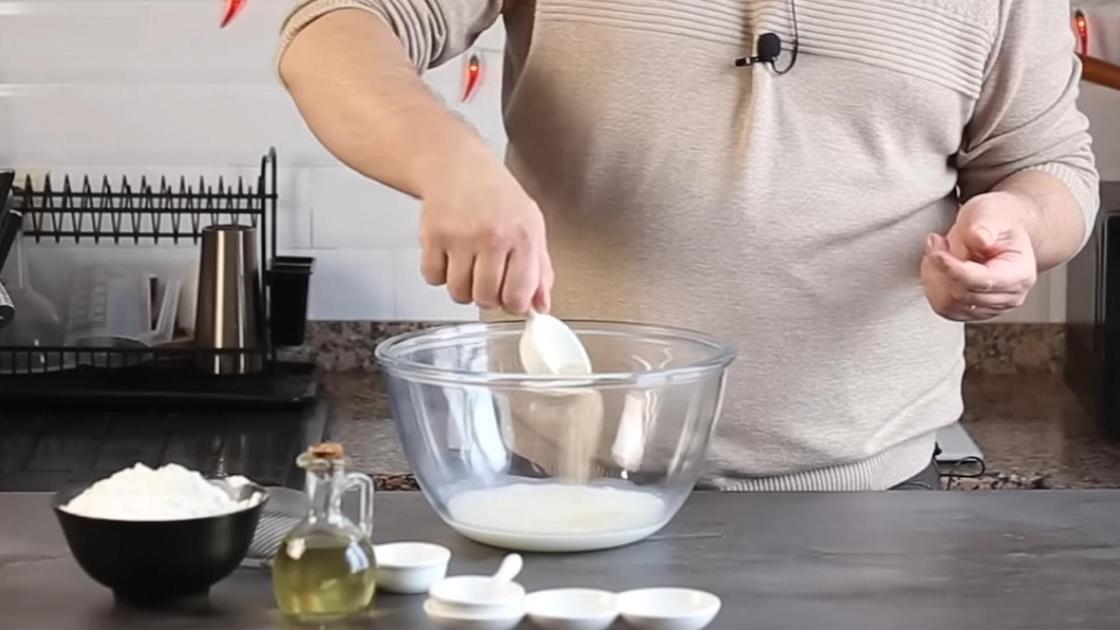 Сухие дрожжи насыпают в миску с молоком и водой