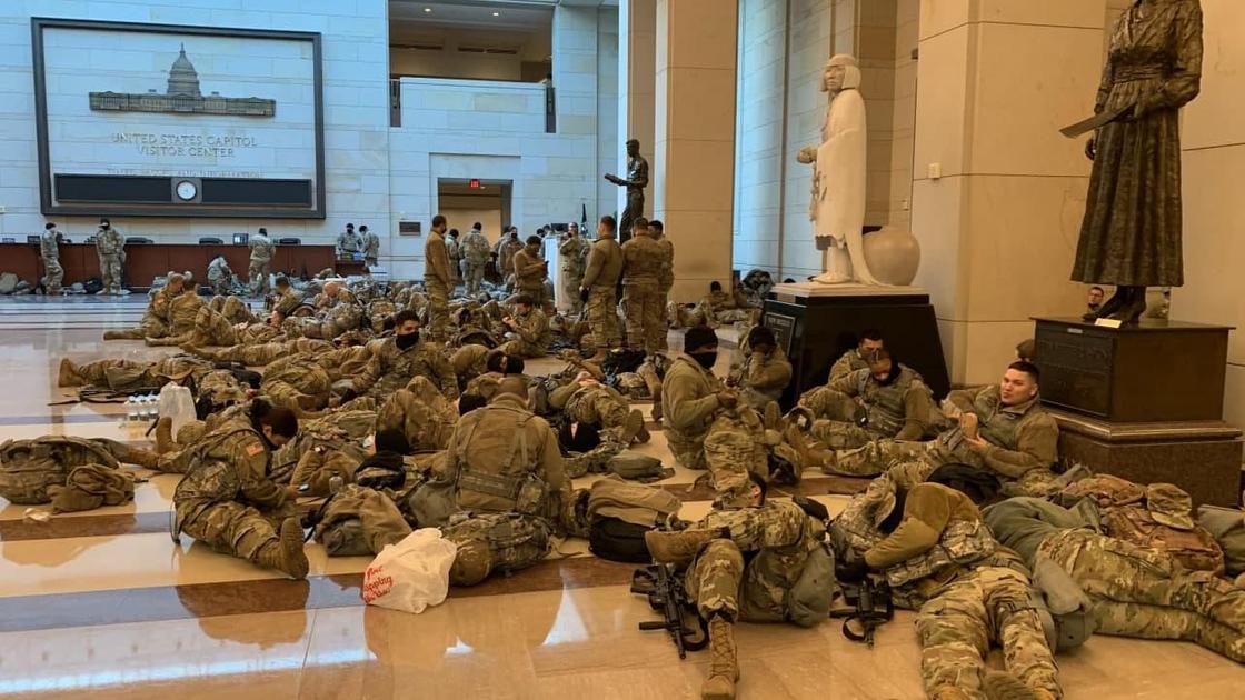 гвардейцы сидят на полу в здании Капитолия в США