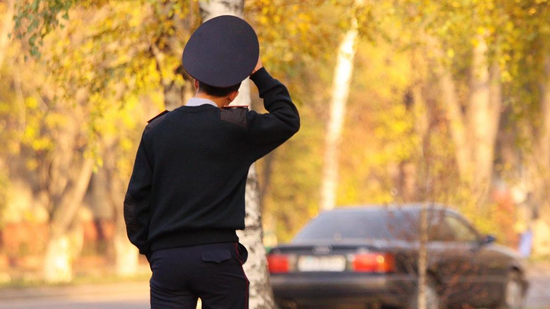 Полицейский идет по улице осенью