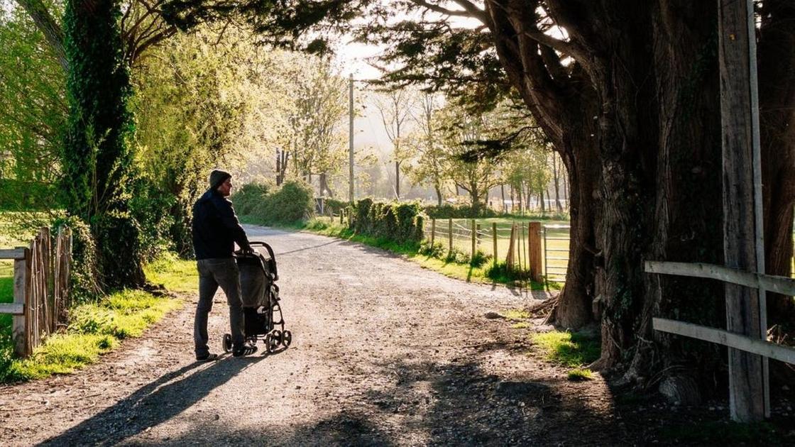 Мужчина гуляет с ребенком в коляске