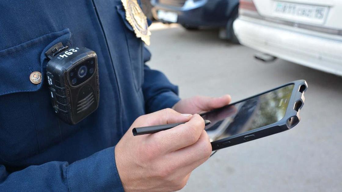 Полицейский вносит данные в планшет