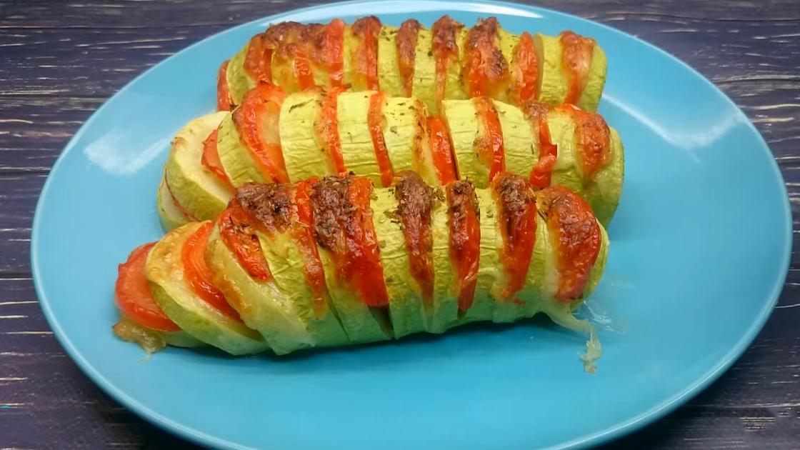 На тарелке запеченные кабачки с помидорами