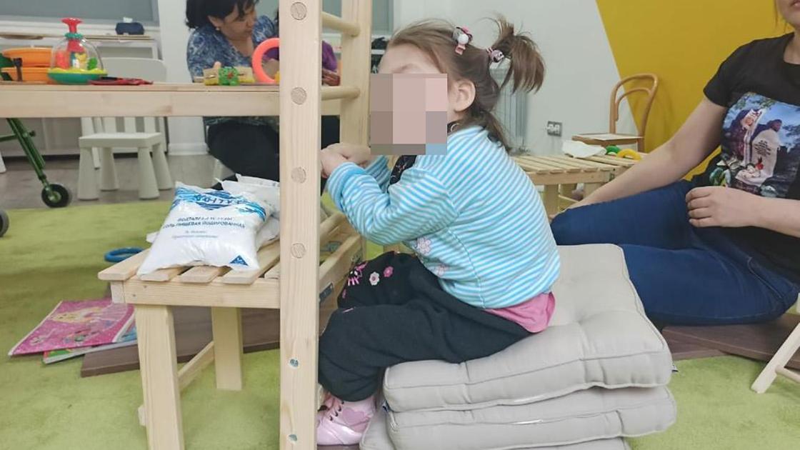 Девочка сидит на подушках в развивающем центре