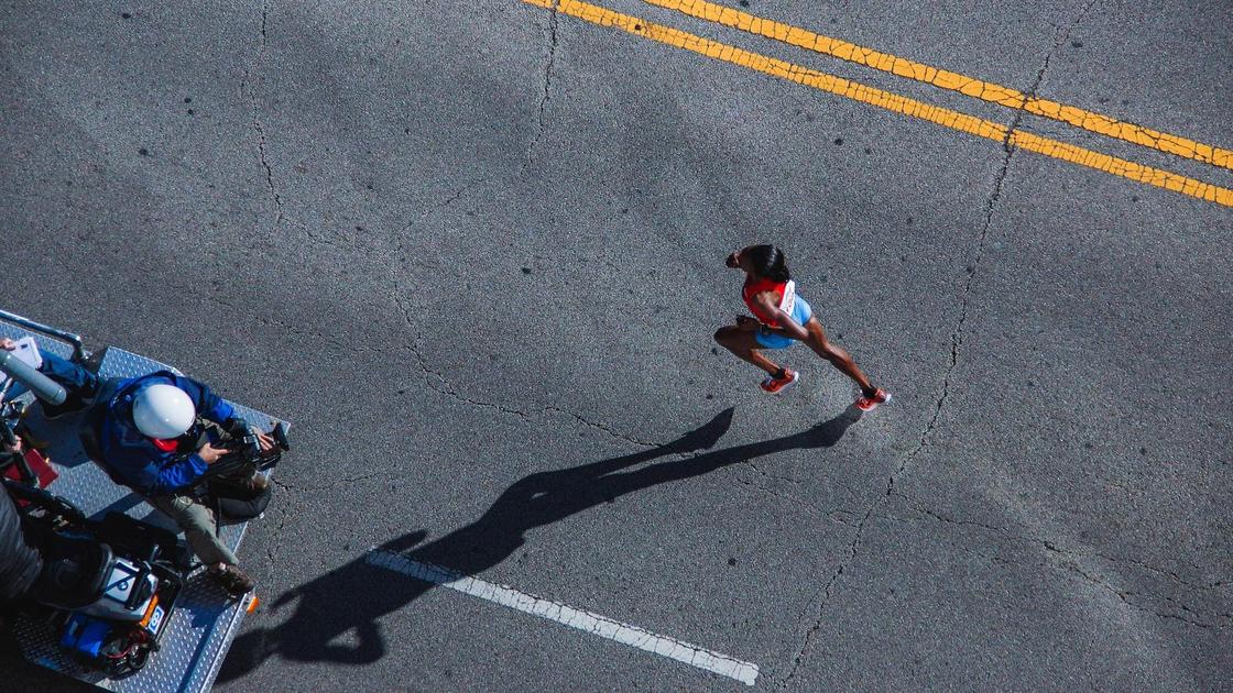 Спортсменка бежит по дороге