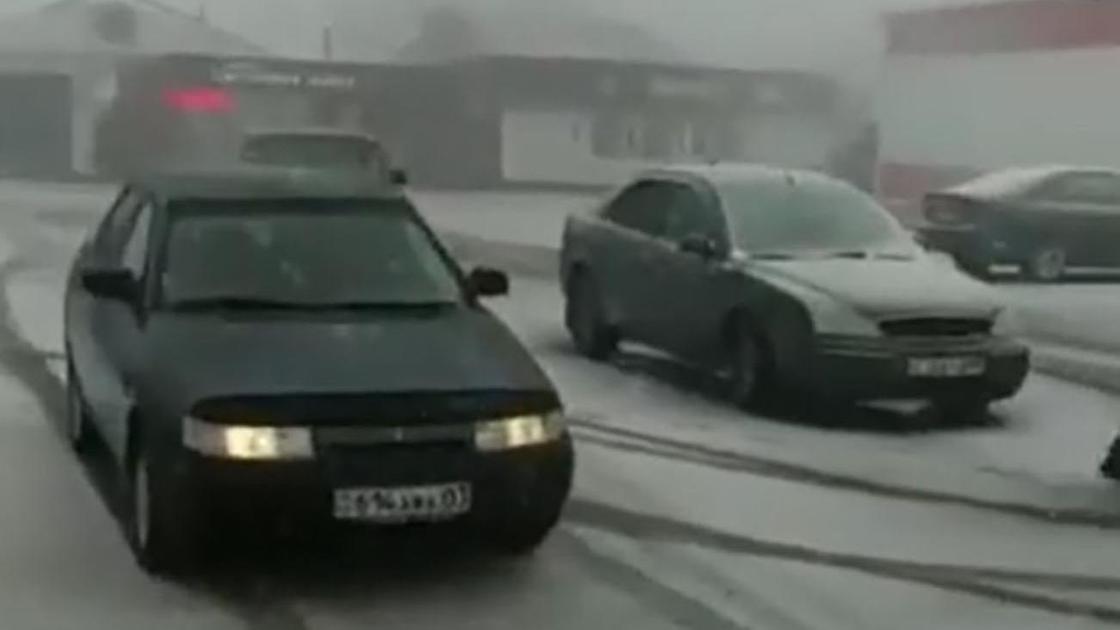 Машины едут во время снега