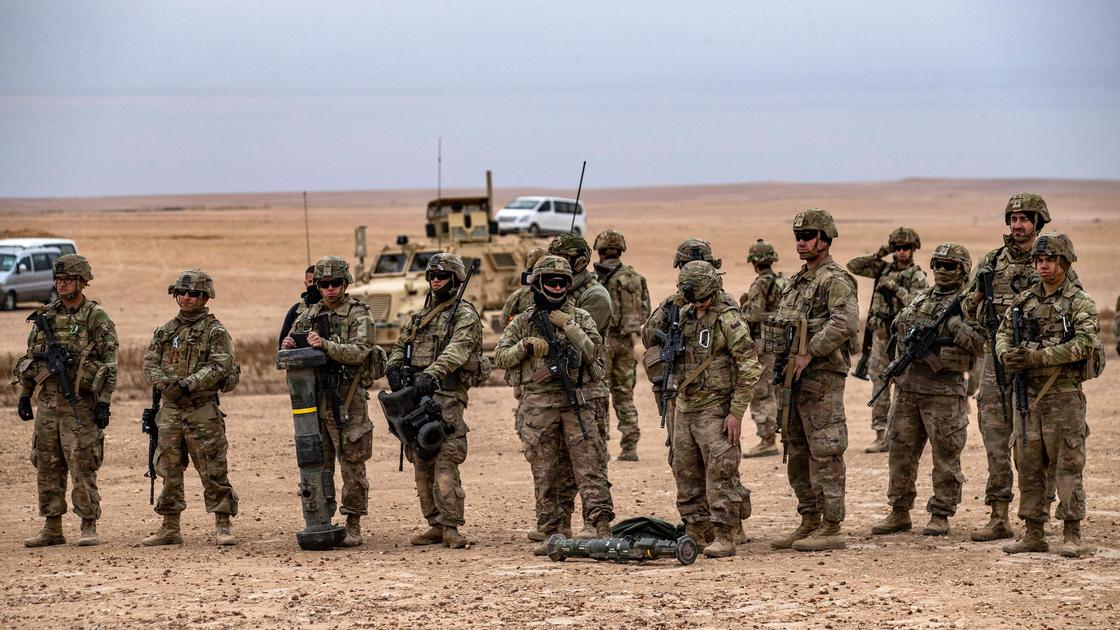 Солдаты на фоне военной техники в пустыне