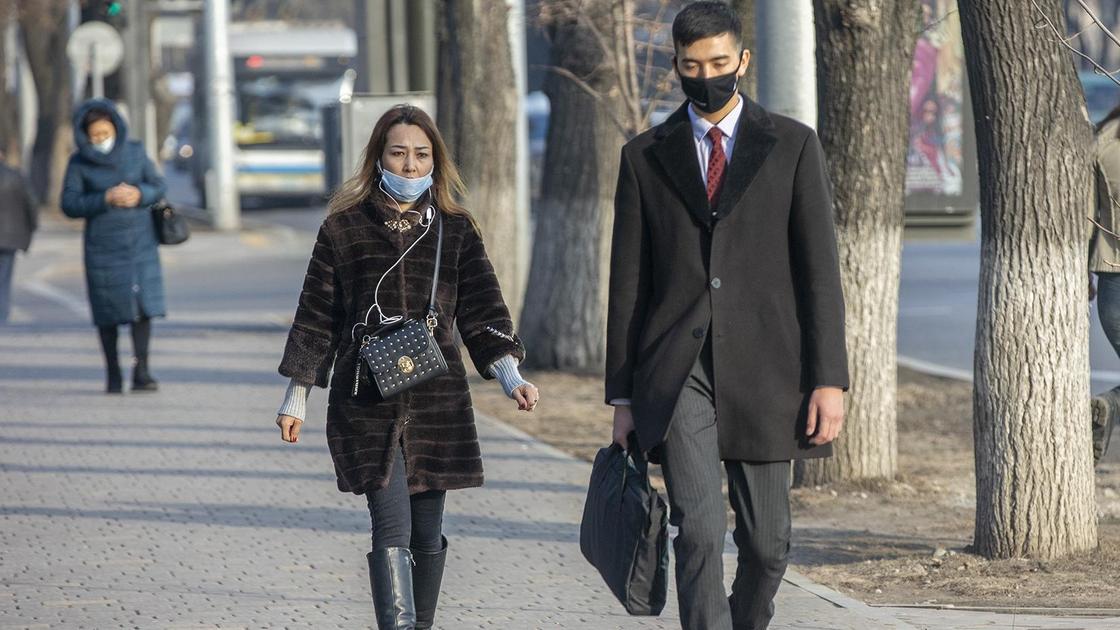 Мужчина и женщина в маске идут по улице