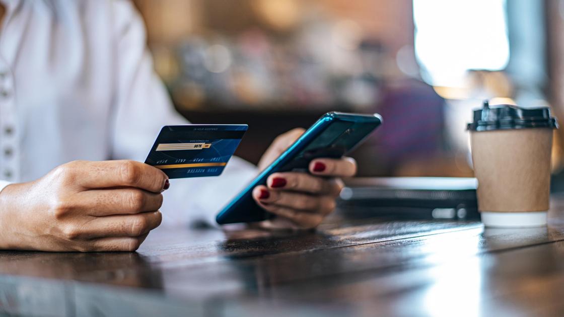 Женщина расплачивается кредитной картой в телефоне