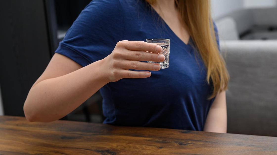 Женщина пьет водку