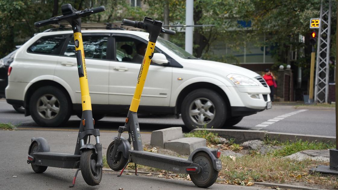Тротуар үстіндегі самокат