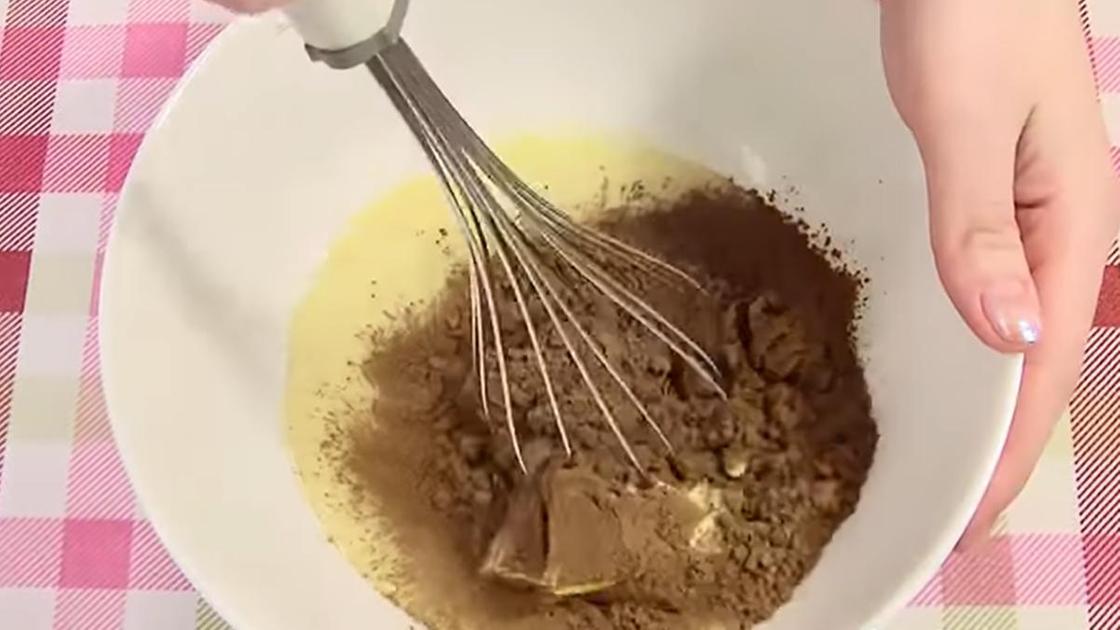 В миску с маслом добавили какао и перемешивают венчиком