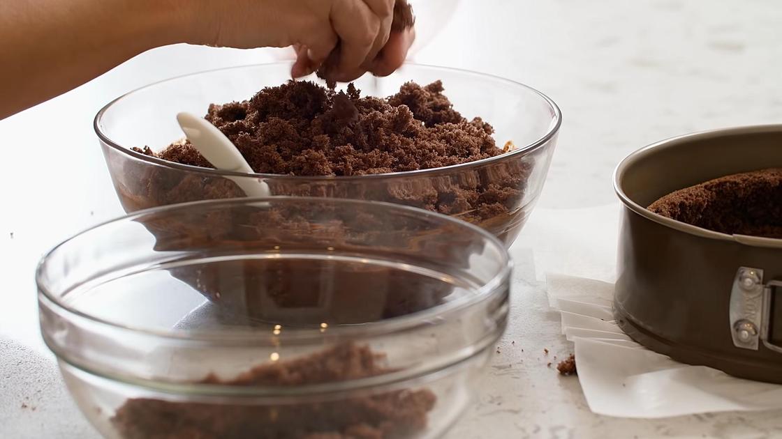 Шоколадную крошку перекладывают из стеклянной емкости в миску с шоколадно-вишневой начинкой