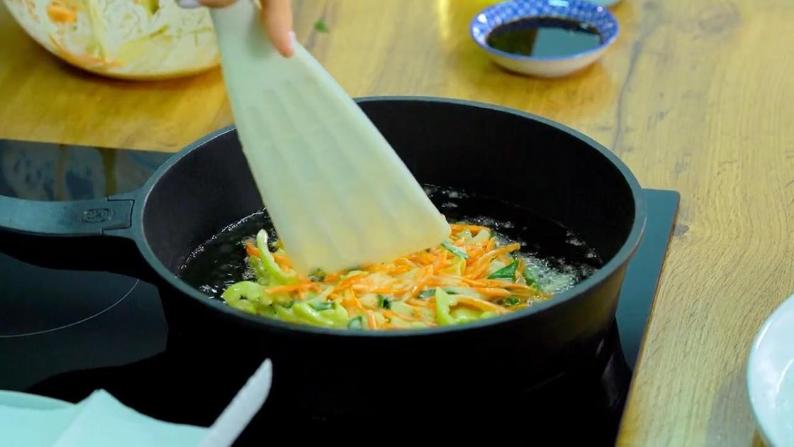 Блин паджон с овощами жарят в масле на сковороде
