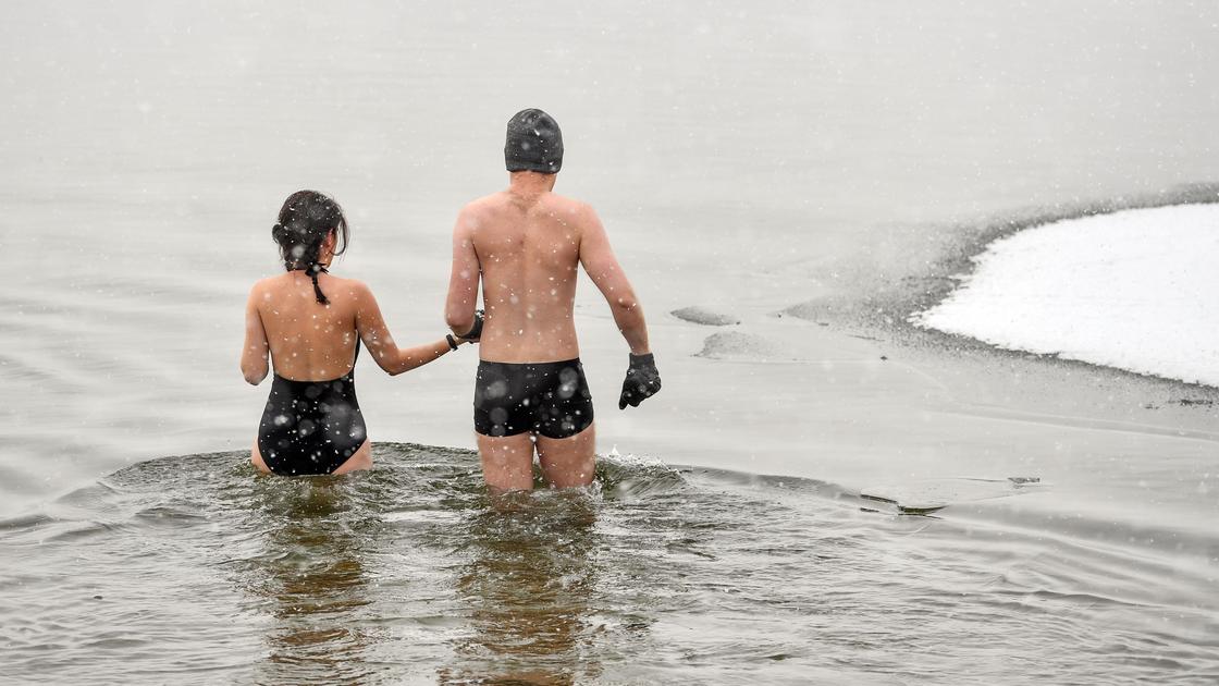Мужчина и женщина заходят в холодную воду зимой