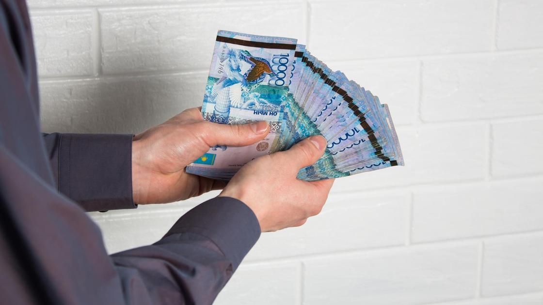 Тенге в руках у мужчины