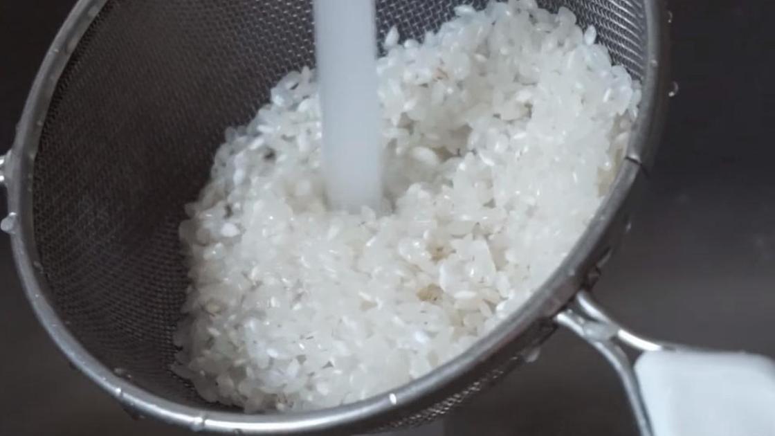 Рис промывают в дуршлаге
