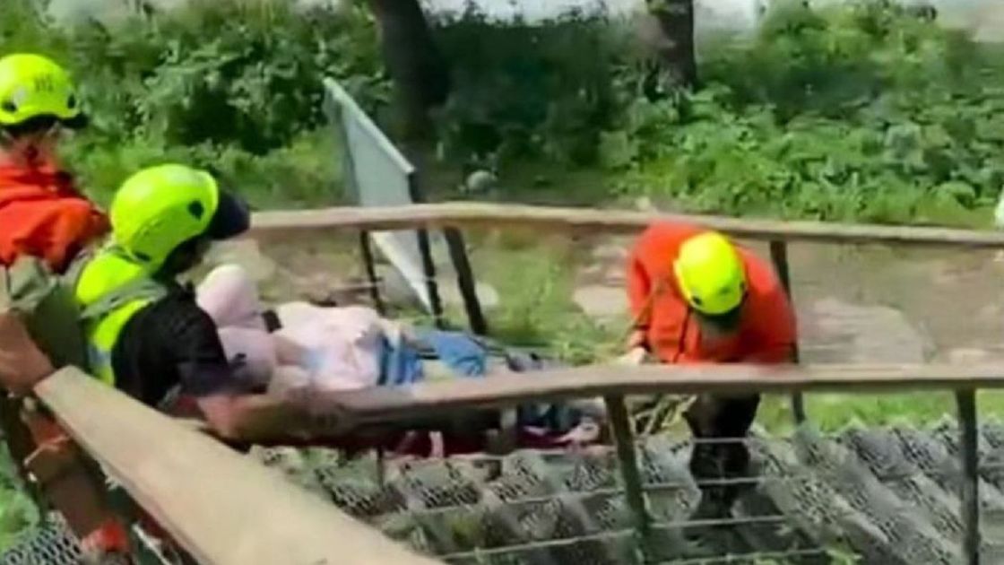 Спасатели несут женщину на носилках