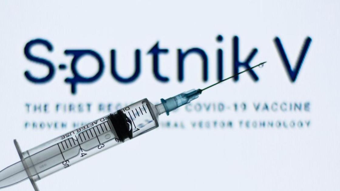Шприц на фоне логотипа вакцины Sputnik V