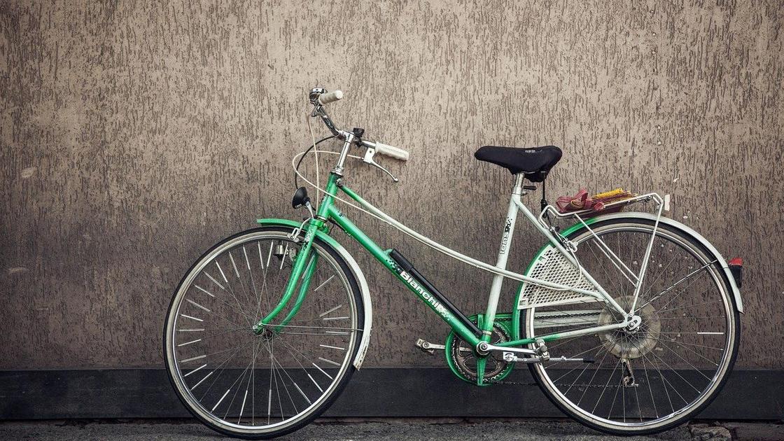 Велосипед облокотили на стену