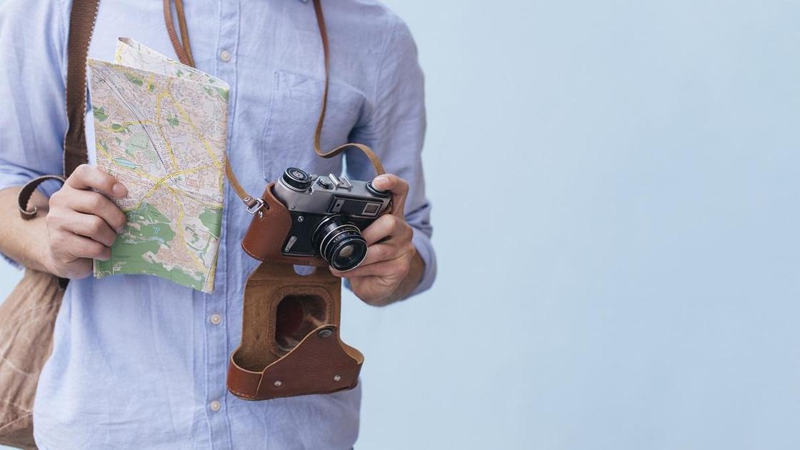 Турист с картой и фотоаппаратом