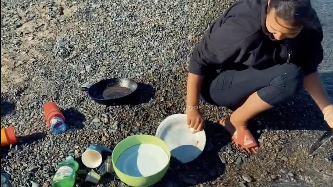 Аиша моет посуду в море