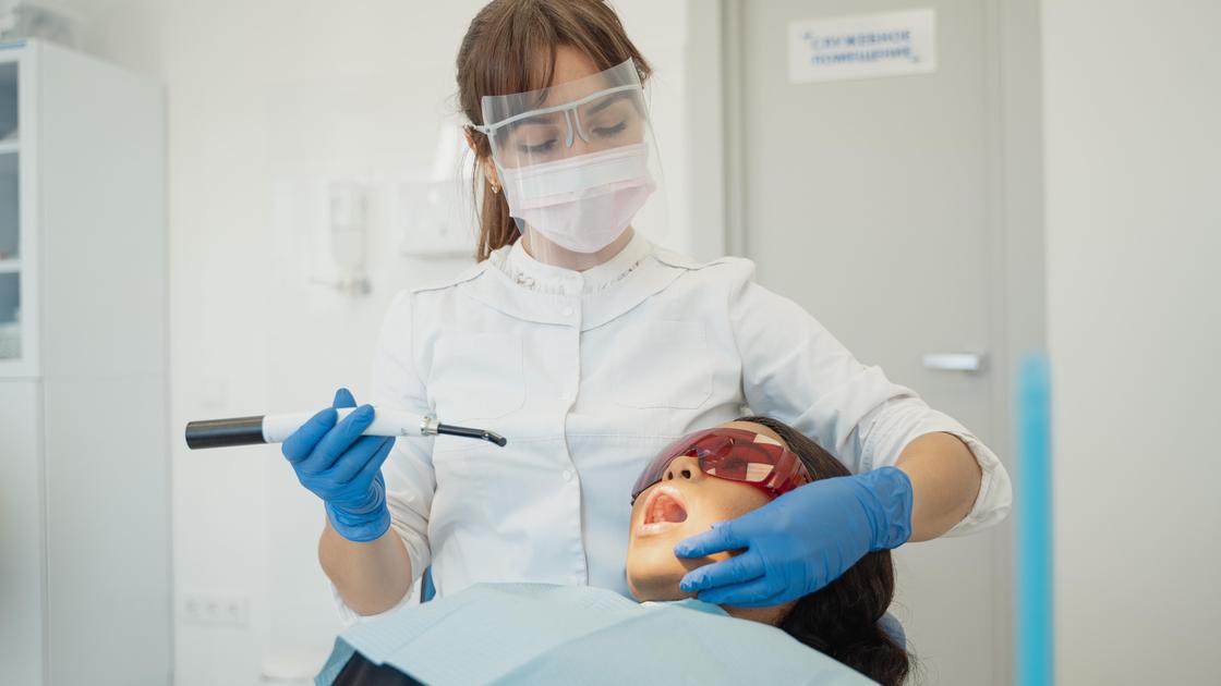 Стоматолог лечит зубы женщине
