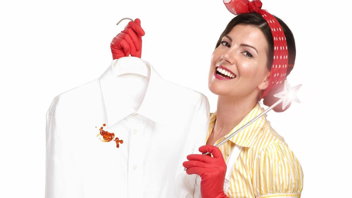 Рубашка с пятном крови на вешалке в руках женщины