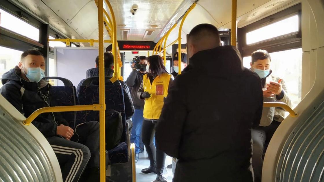 Пассажиры стоят в салоне автобуса