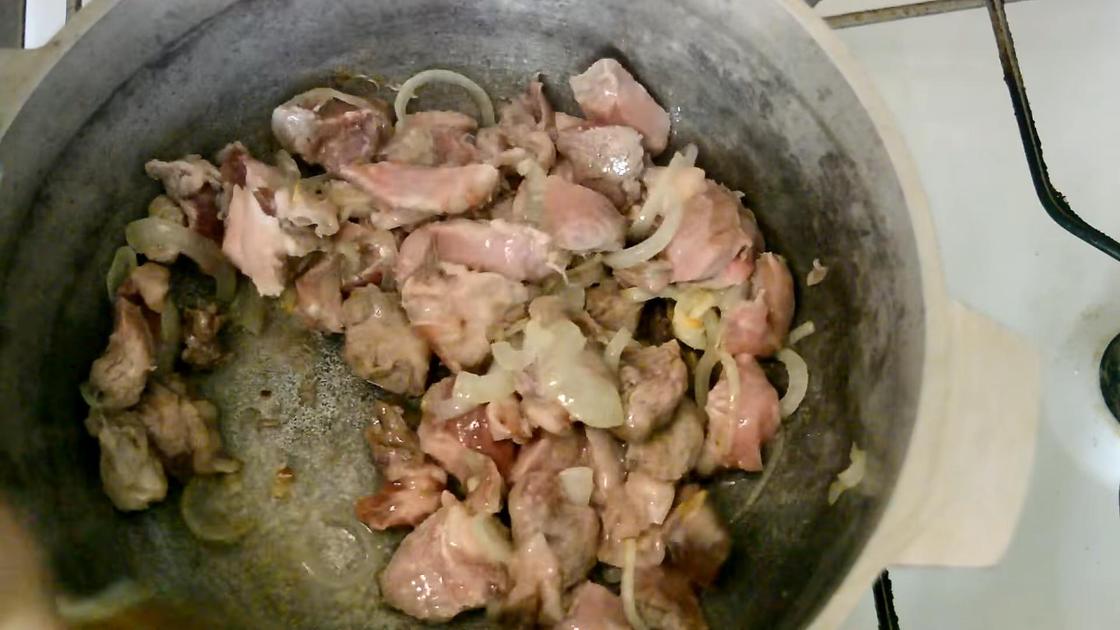 Обжарка лука с кусочками свинины в казане
