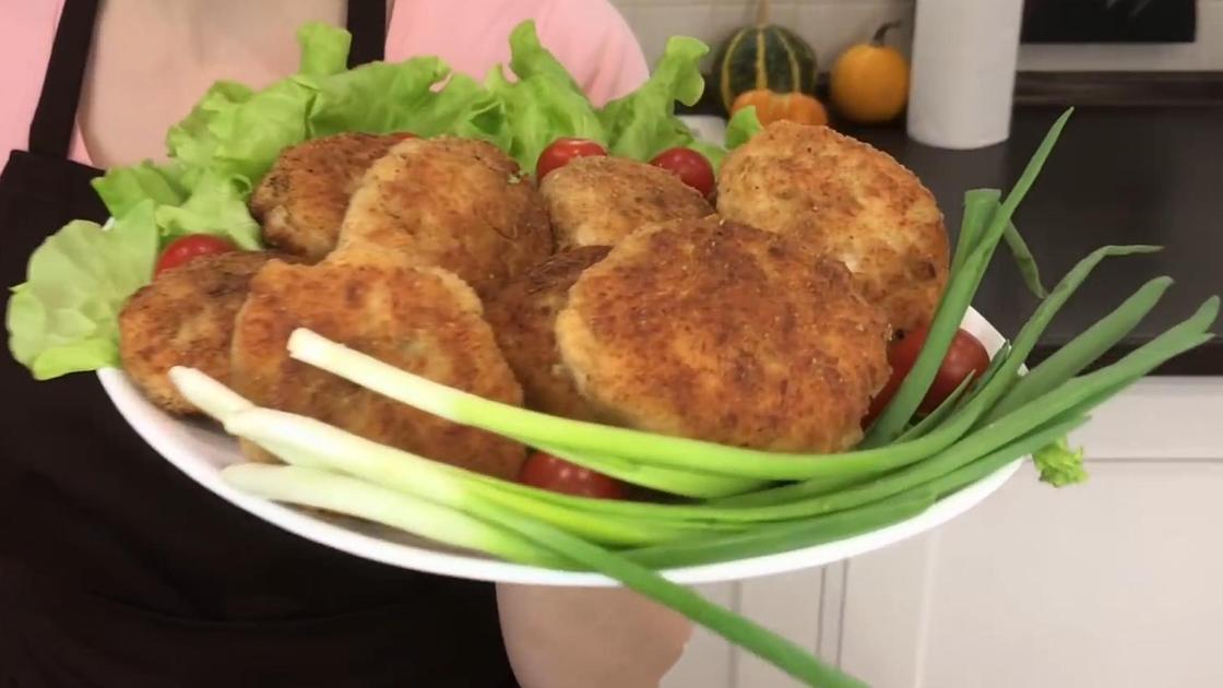 На тарелке мясные зразы и зеленый лук перьями
