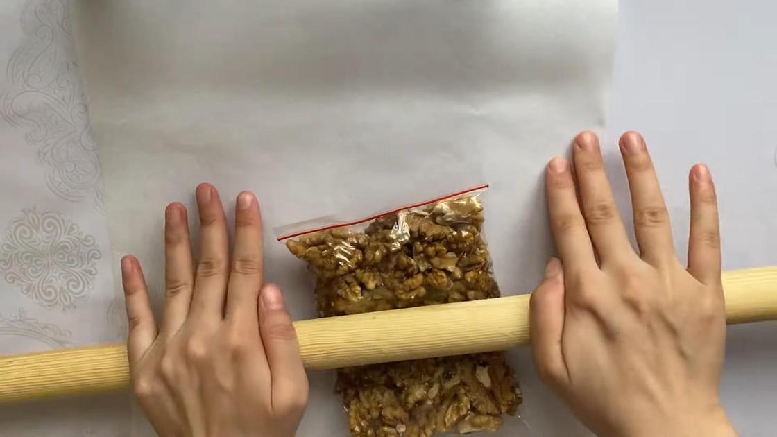 Орехи в полиэтиленовом пакете измельчают скалкой