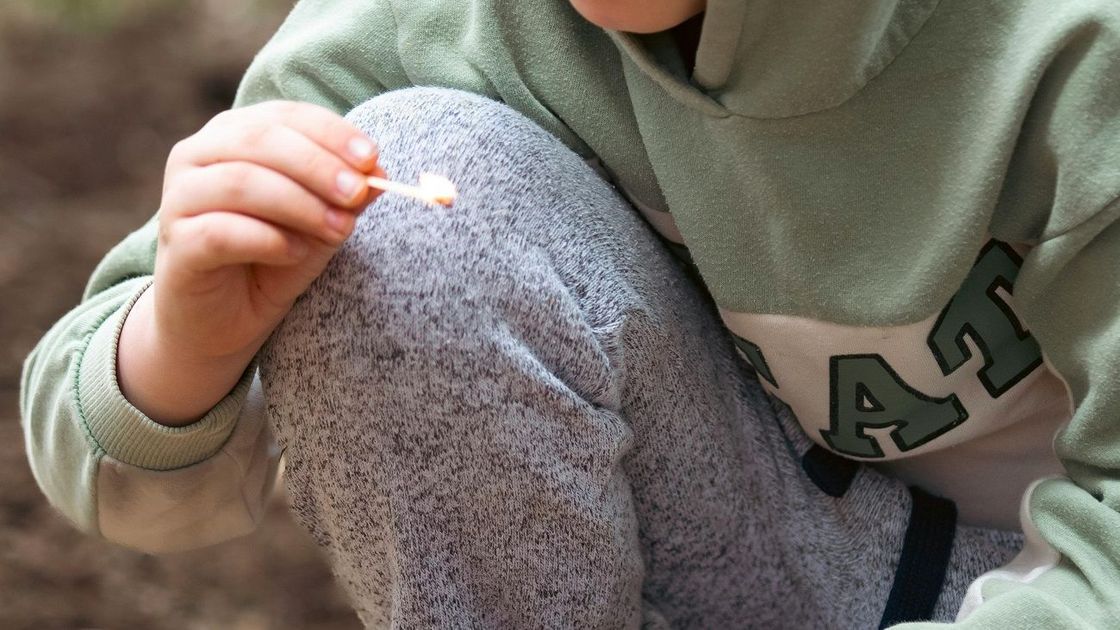 Мальчик держит спичку