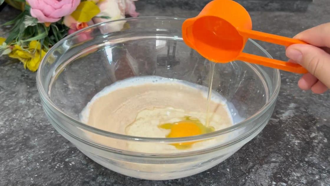 В стеклянную миску с молоком и дрожжами добавляют яйцо