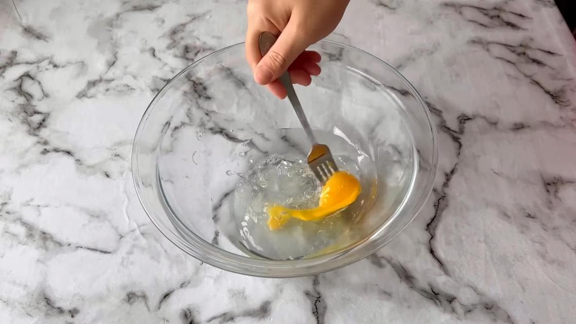 В стеклянной миске смешивают яйцо с водой