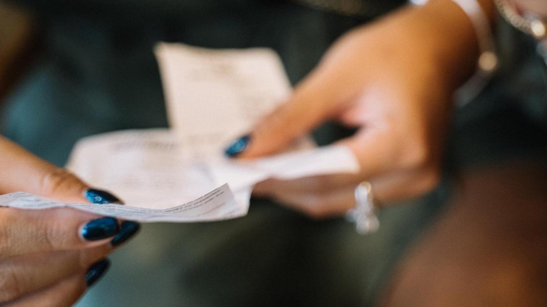 Женщина держит квитанции в руках